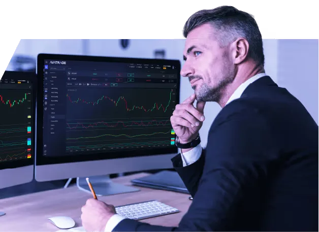 A trader studying charts on a desktop monitor
