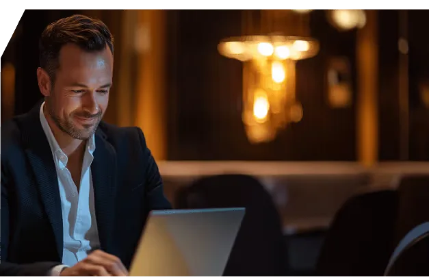 A trader working at his laptop in the evening